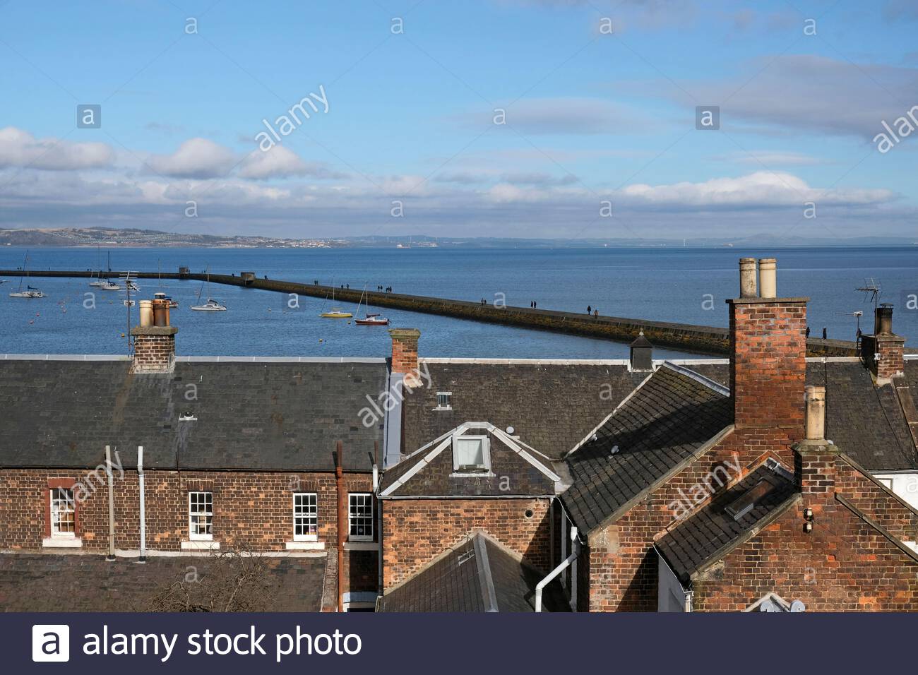 View over rooftops towards Granton harbour and breakwater in the Firth of Forth Estuary, Edinburgh, Scotland Stock Photo