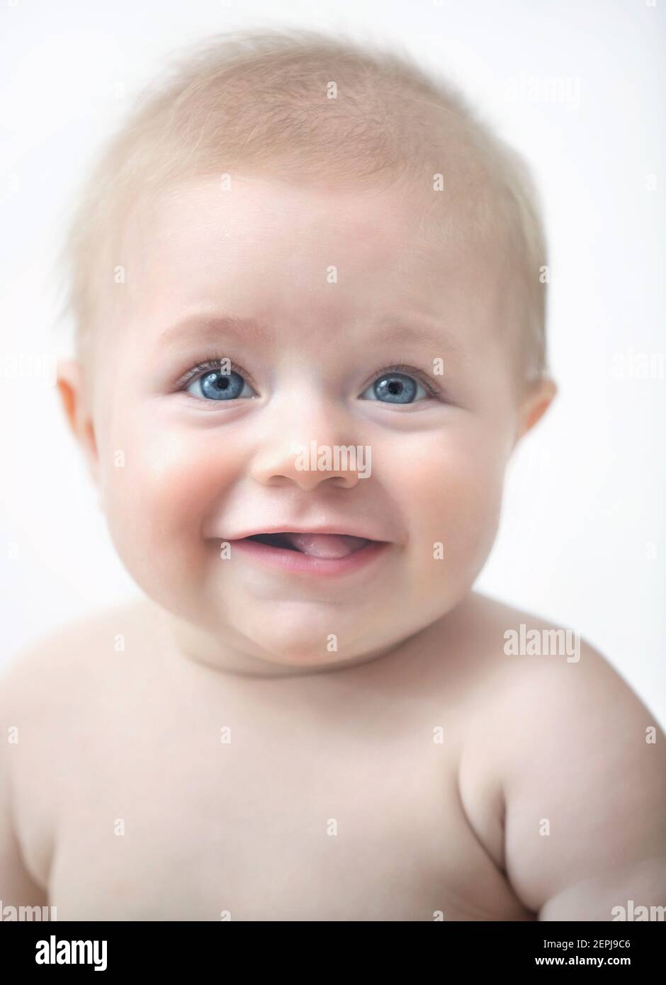 A happy, adorable blond baby with blue eyes. Stock Photo