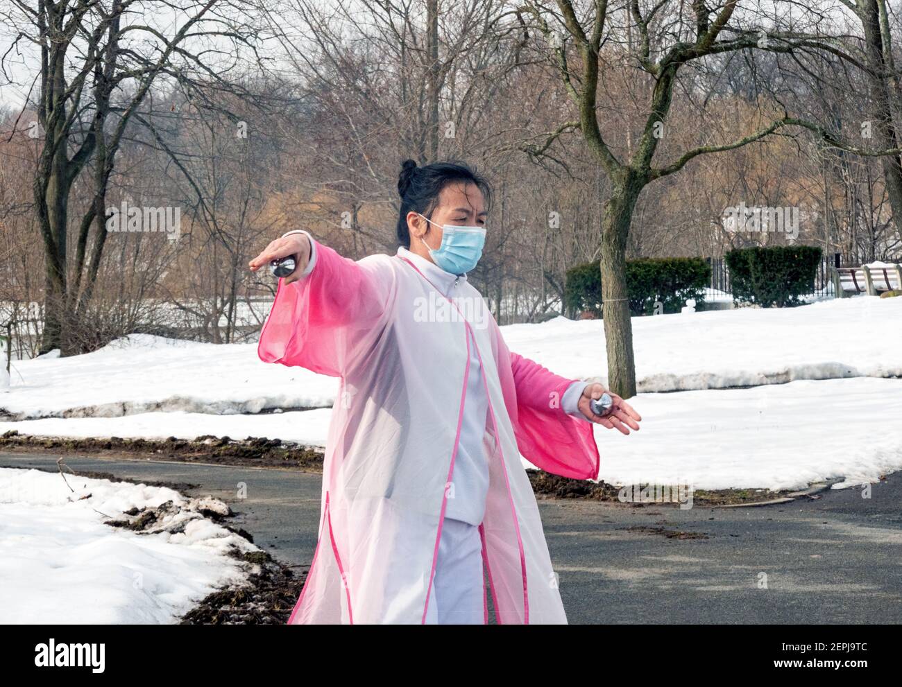 A middle aged Chinese American woman gracefully does Tai Chi dance exercises with silver balls. In a park in Flushing, Queens, New York City. Stock Photo