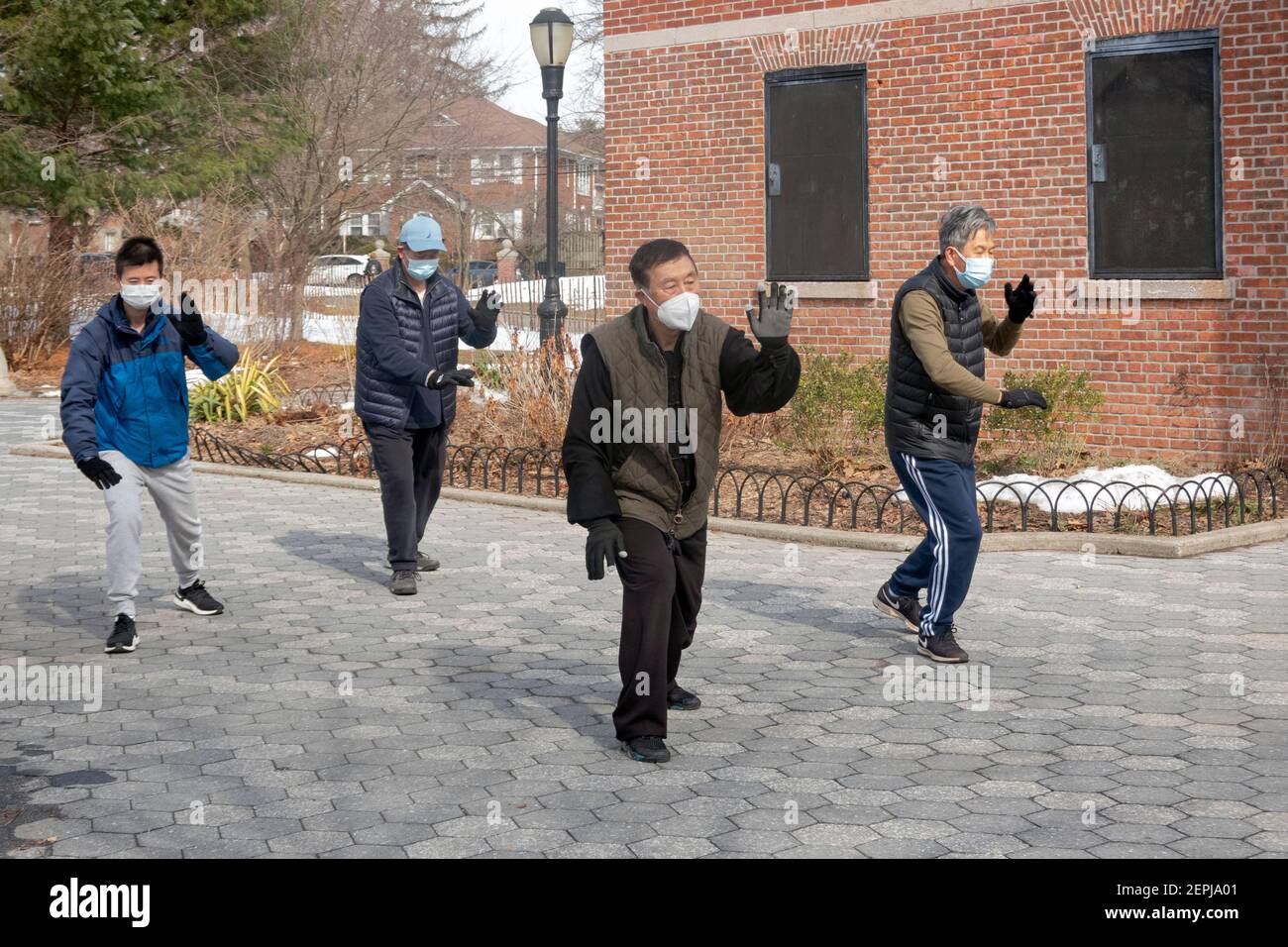 Four Chinese American men of varying age do Tai Chi exercises on a cold winter morning. In a park in Queens, New York City. Stock Photo