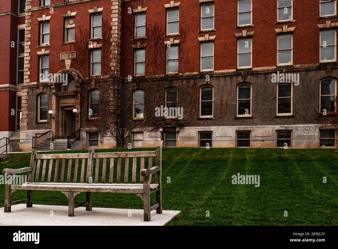 Bench in front of building on the campus of Syracuse University in Syracuse, New York Stock Photo