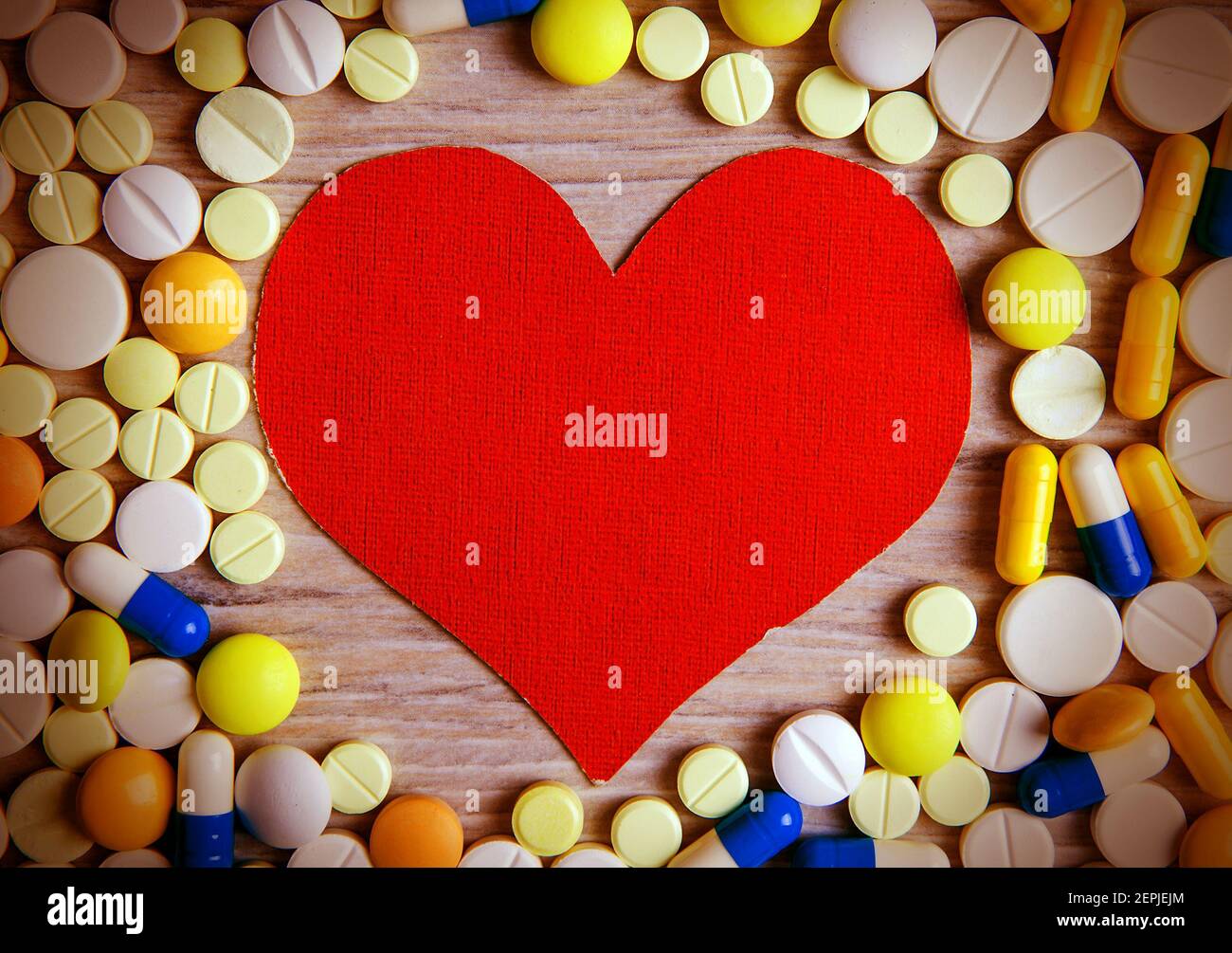 Toned Photo of Red Heart Shape with a Pills on the Table closeup Stock Photo
