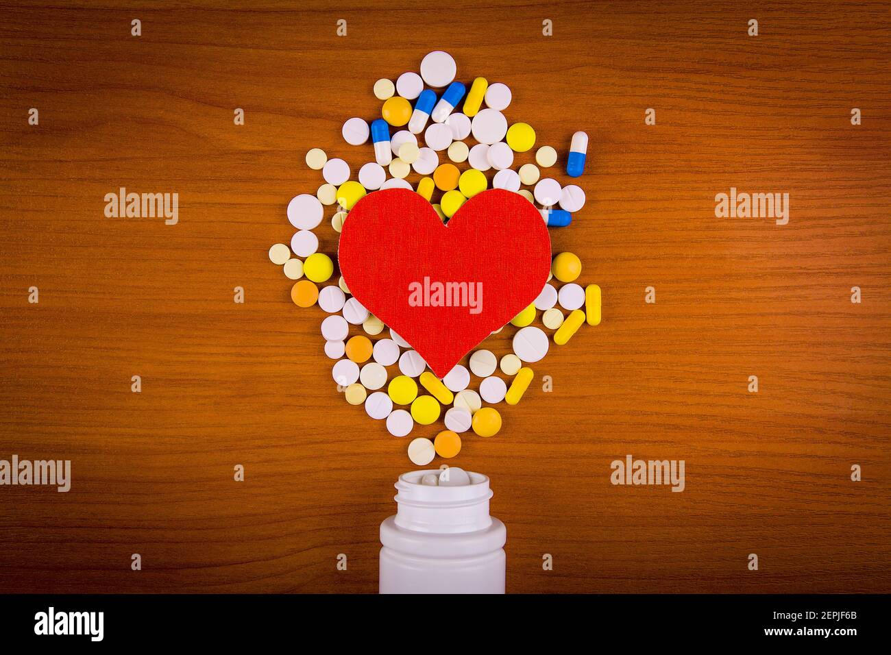 Red Heart Shape with a Pills on the Table closeup Stock Photo