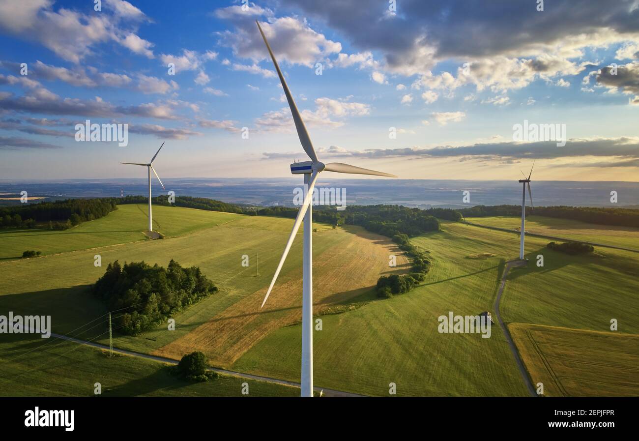 Aerial of wind turbine farm. Wind power plants in green landscape sunset sky with clouds. Aerial, drone inspection of wind turbine Stock Photo Alamy