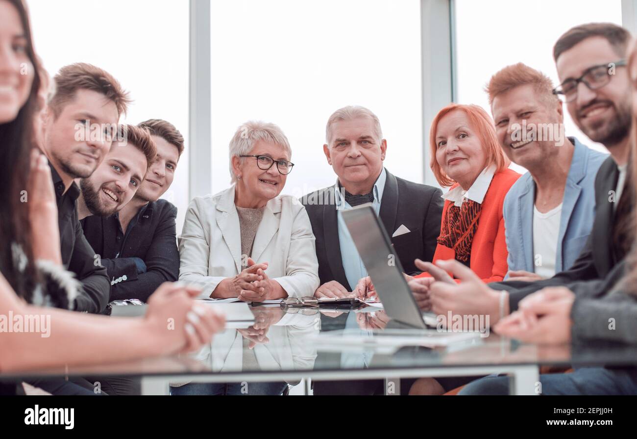 Happy business people sitting around the table Stock Photo