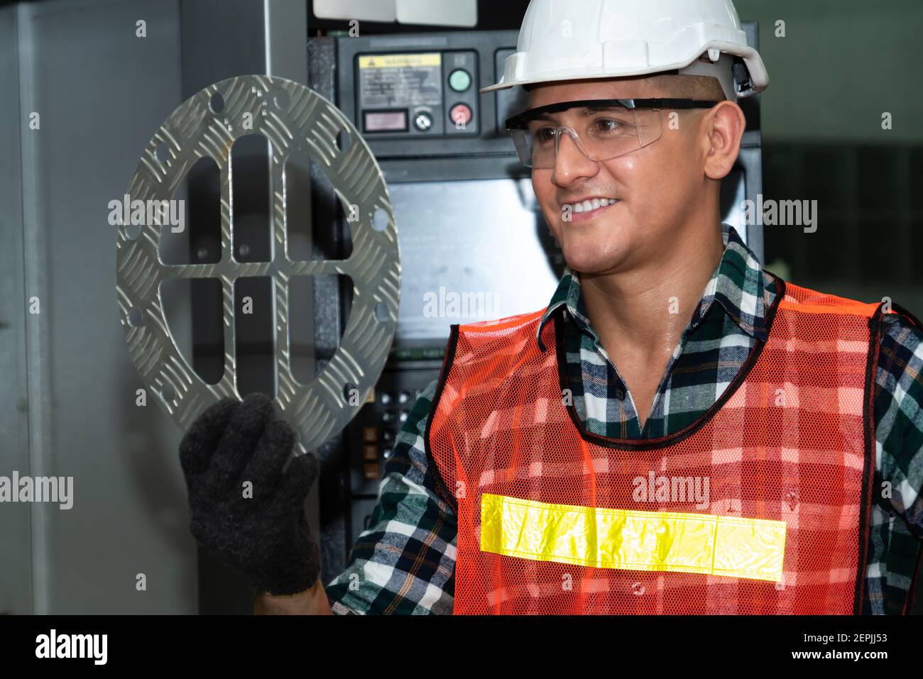 Smart factory job worker looking at machine part in manufacturing