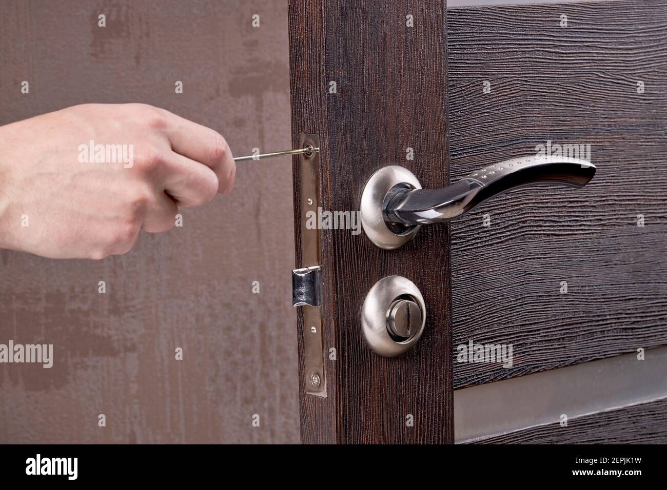 person fixing door furniture using screwdriver. improvement process Stock Photo