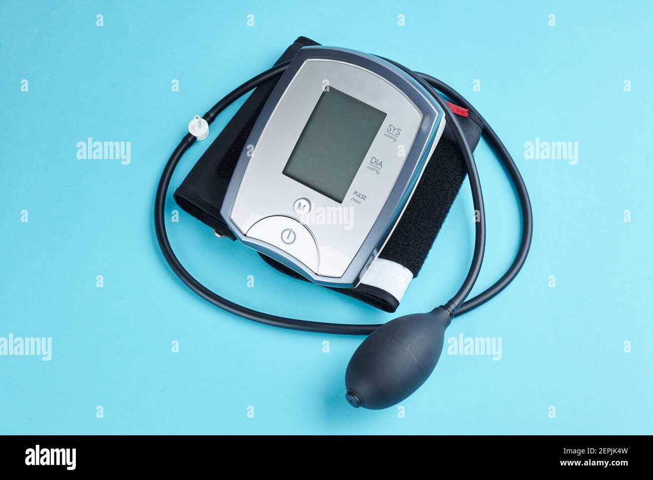 measuring blood pressure with electronic medical device over blue