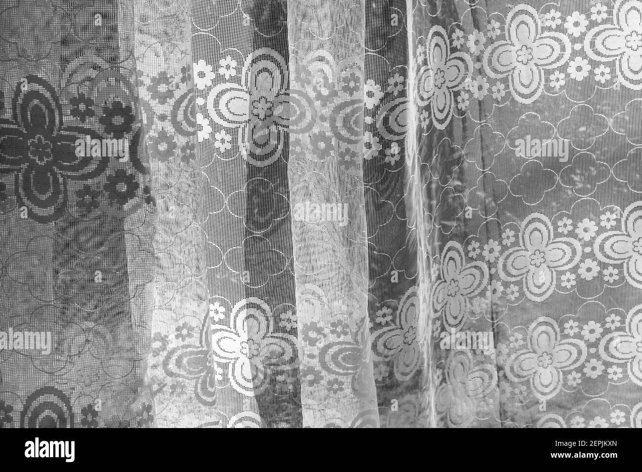 Real curtain made of white tulle with patterns in black and white Stock Photo