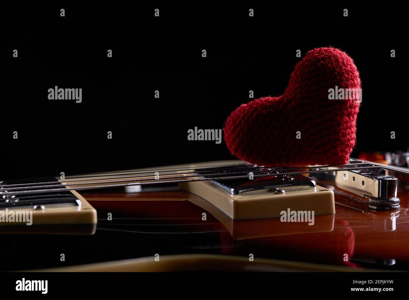 love music concept. electric guitar with red heart on it. dark moody