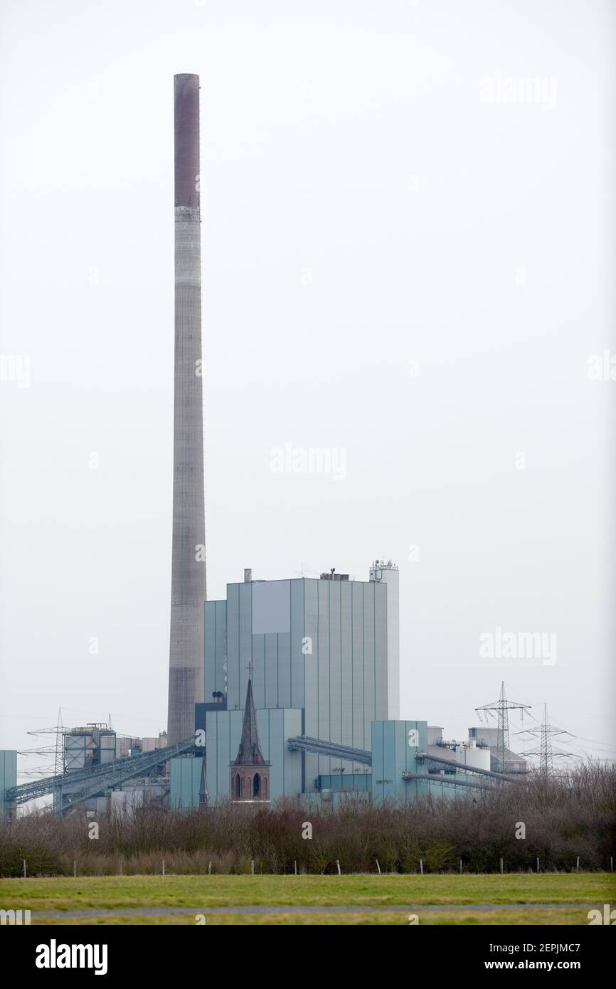 Das Heizkraftwerk in Dueisburg Walsum vor grauem Himmel. Vor dem Kraftwerk ist klein ein Kirchturm zu sehen. Stock Photo