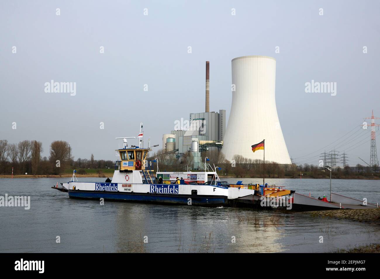 Die Rheinfaehre nach Orsoy legt in Richtung Dueisburg Walsum ab. Der Blick kommt aus Richtung Orsoy. Im Hintergrund ist das Kraftwerk Walsum mit dem m Stock Photo