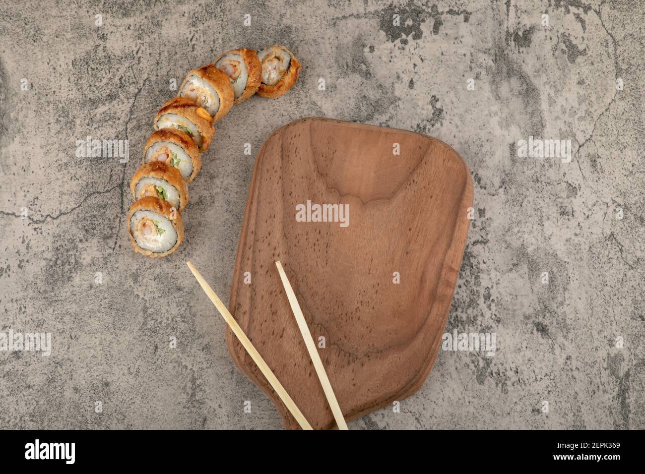 Breaded sushi hot rolls with wooden board and chopsticks Stock Photo