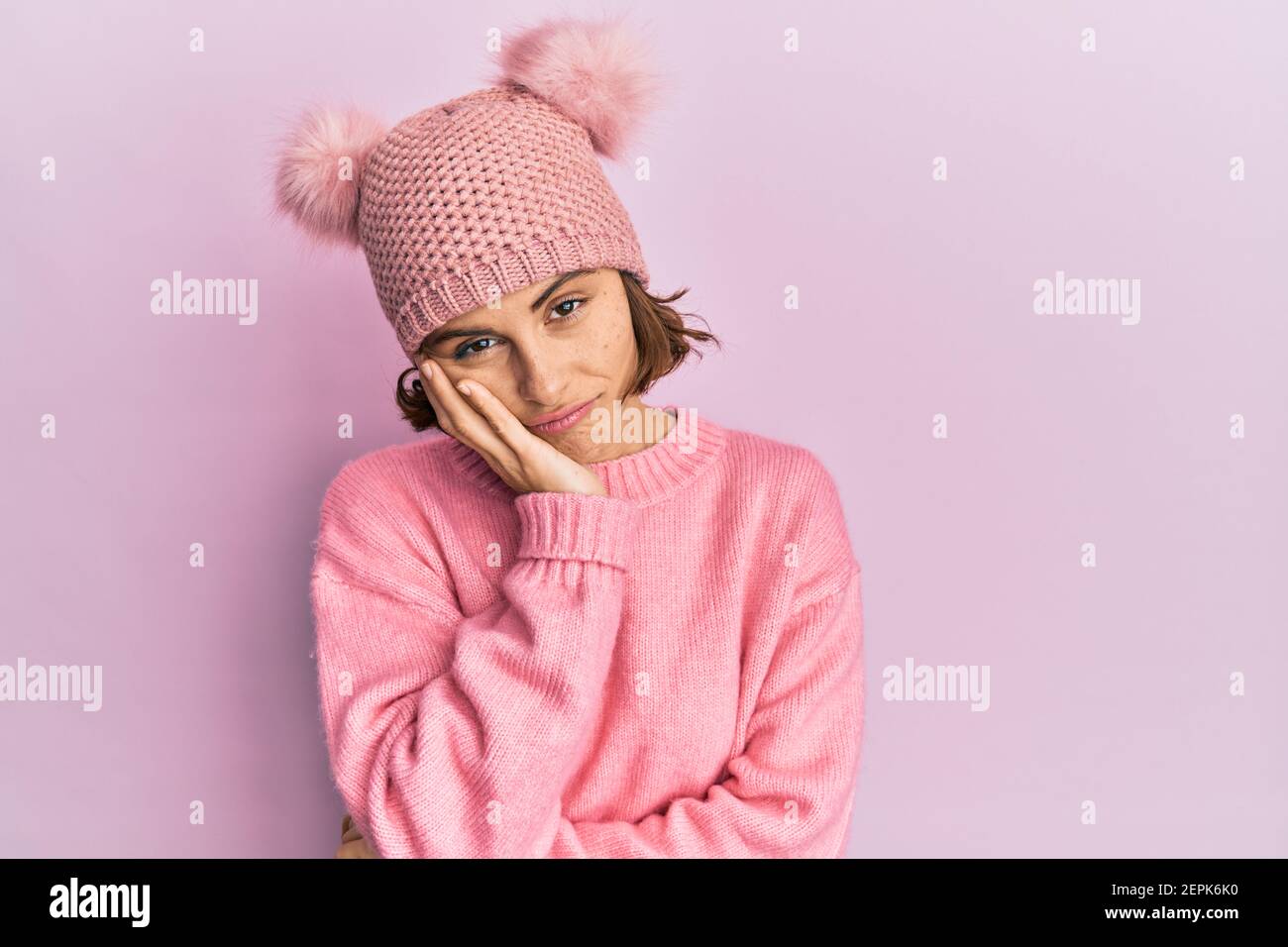 Young brunette woman wearing cute wool cap thinking looking tired and bored with depression problems with crossed arms. Stock Photo