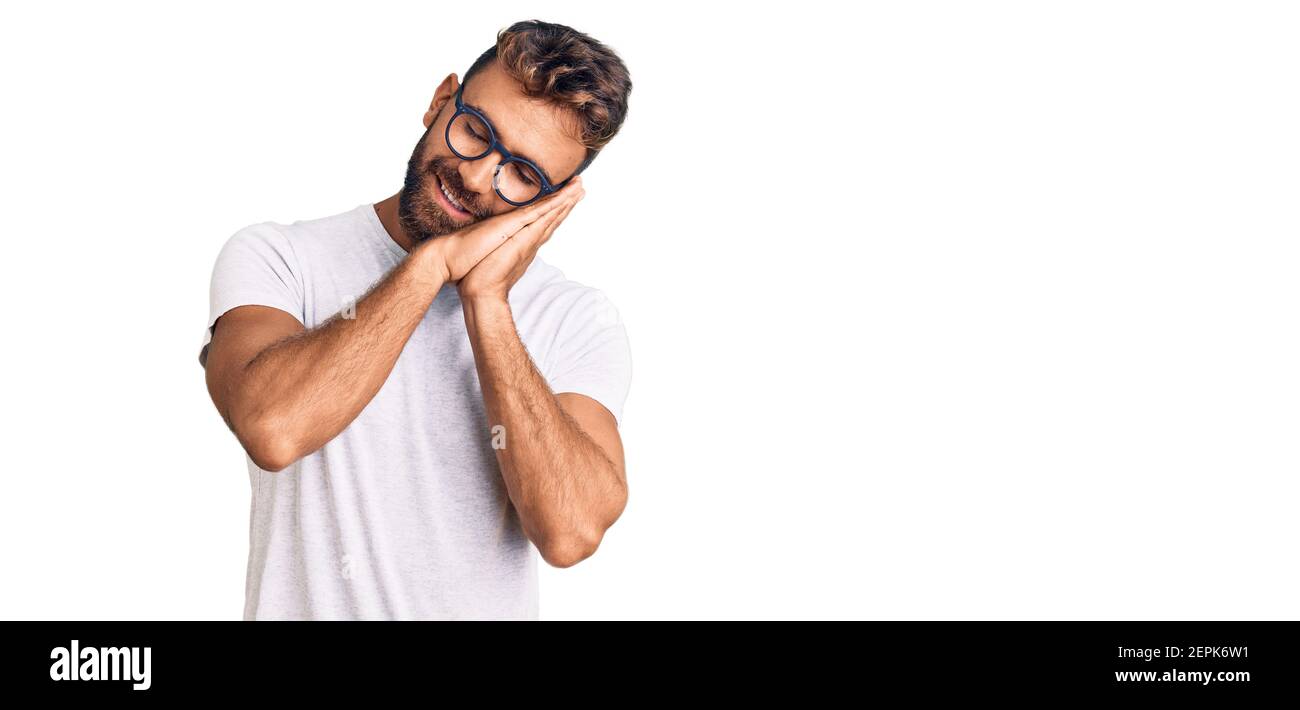 Young hispanic man wearing casual clothes and glasses sleeping tired ...