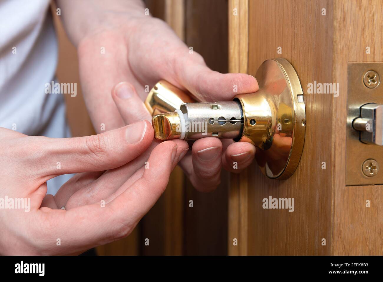 Install the door handle with a lock, man hands repair door knob, repair locking mechanism Stock Photo