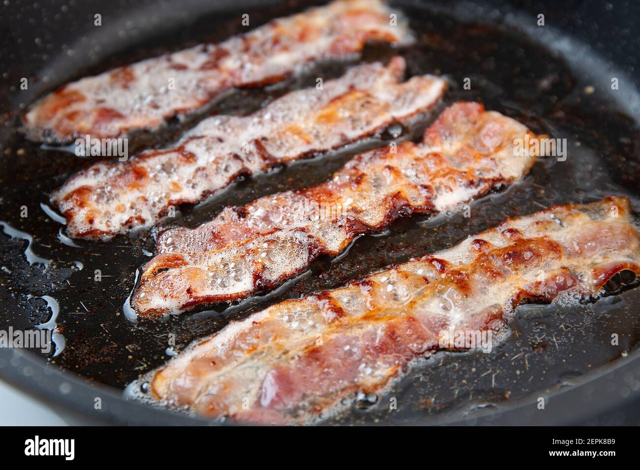 Crispy smokey bacon slice or strip. Unhealthy fat food, fattenig