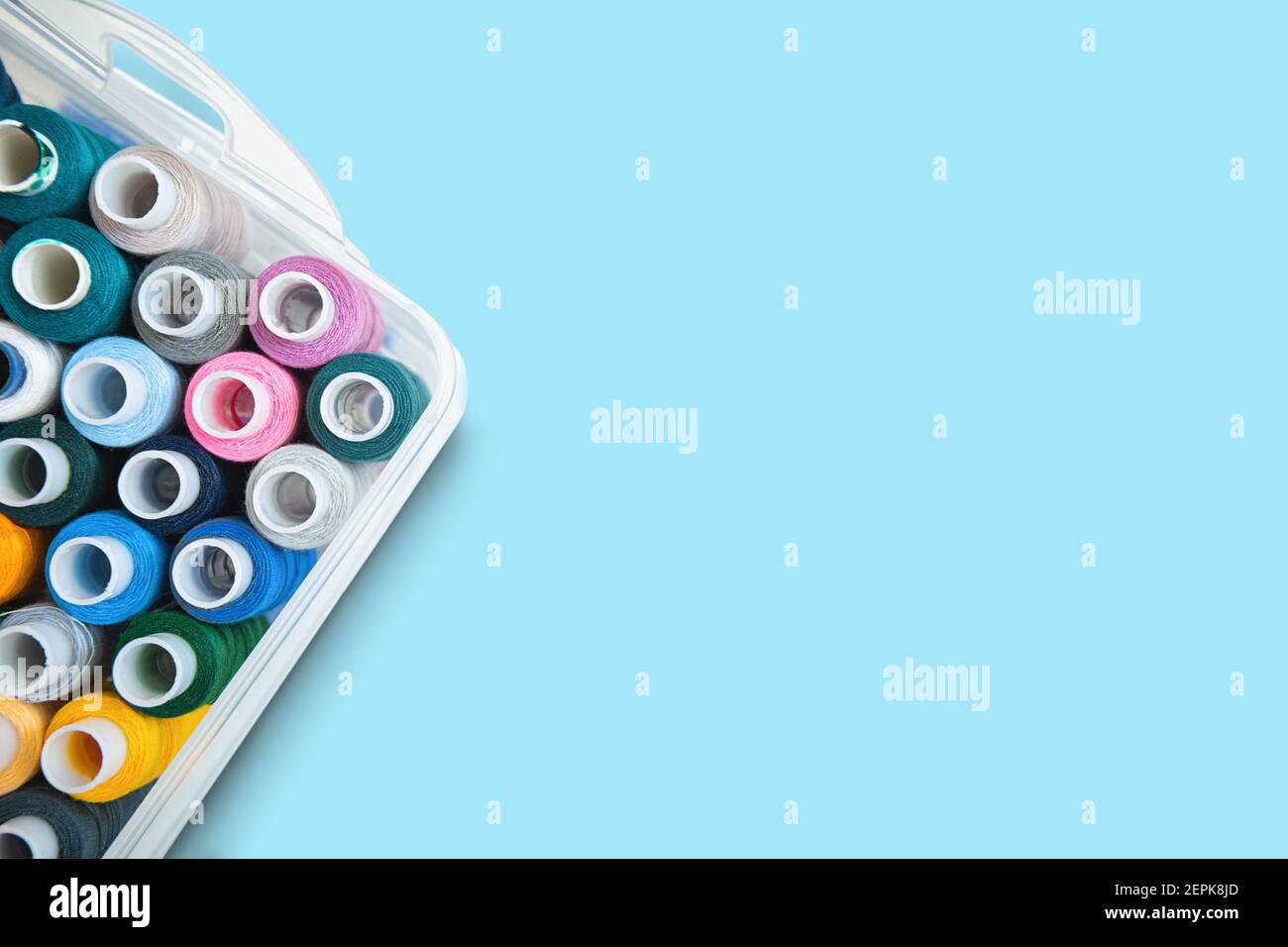 Colored needles and thread reel on patterned fabric placed on the left  side, copy space, white background, top view, sewing and embroidery concept  Stock Photo - Alamy