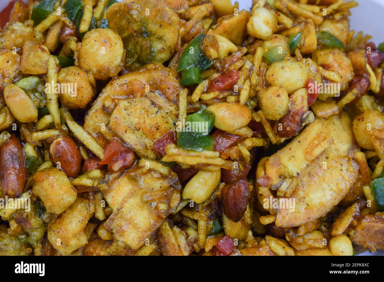 Closeup of Farali bhelpuri made with faradi ingredients like banana chips, sago balls, mixture, tomato, capsicum on white background. Eaten during Fas Stock Photo