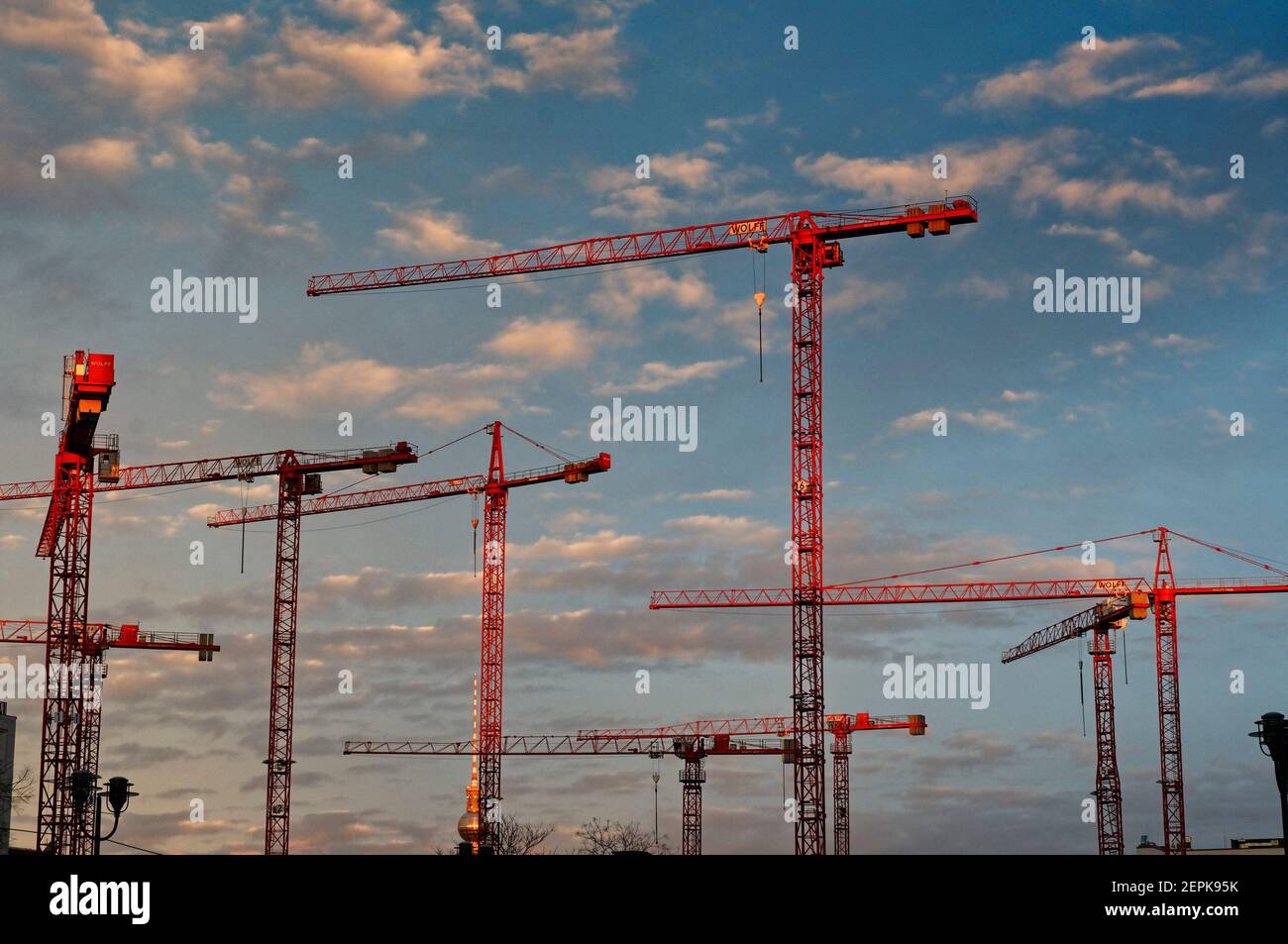 Constructions cranes seen against a sunset sky Stock Photo