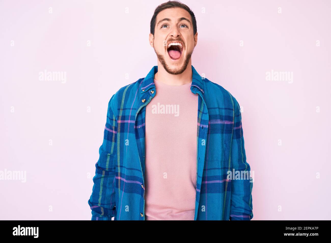 Young handsome man wearing casual clothes angry and mad screaming ...