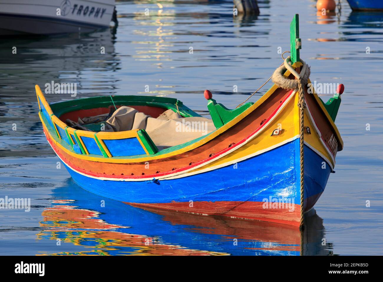 A luzzu (Maltese traditional fishing boat) in moored in the marina of Marsaxlokk, Malta Stock Photo