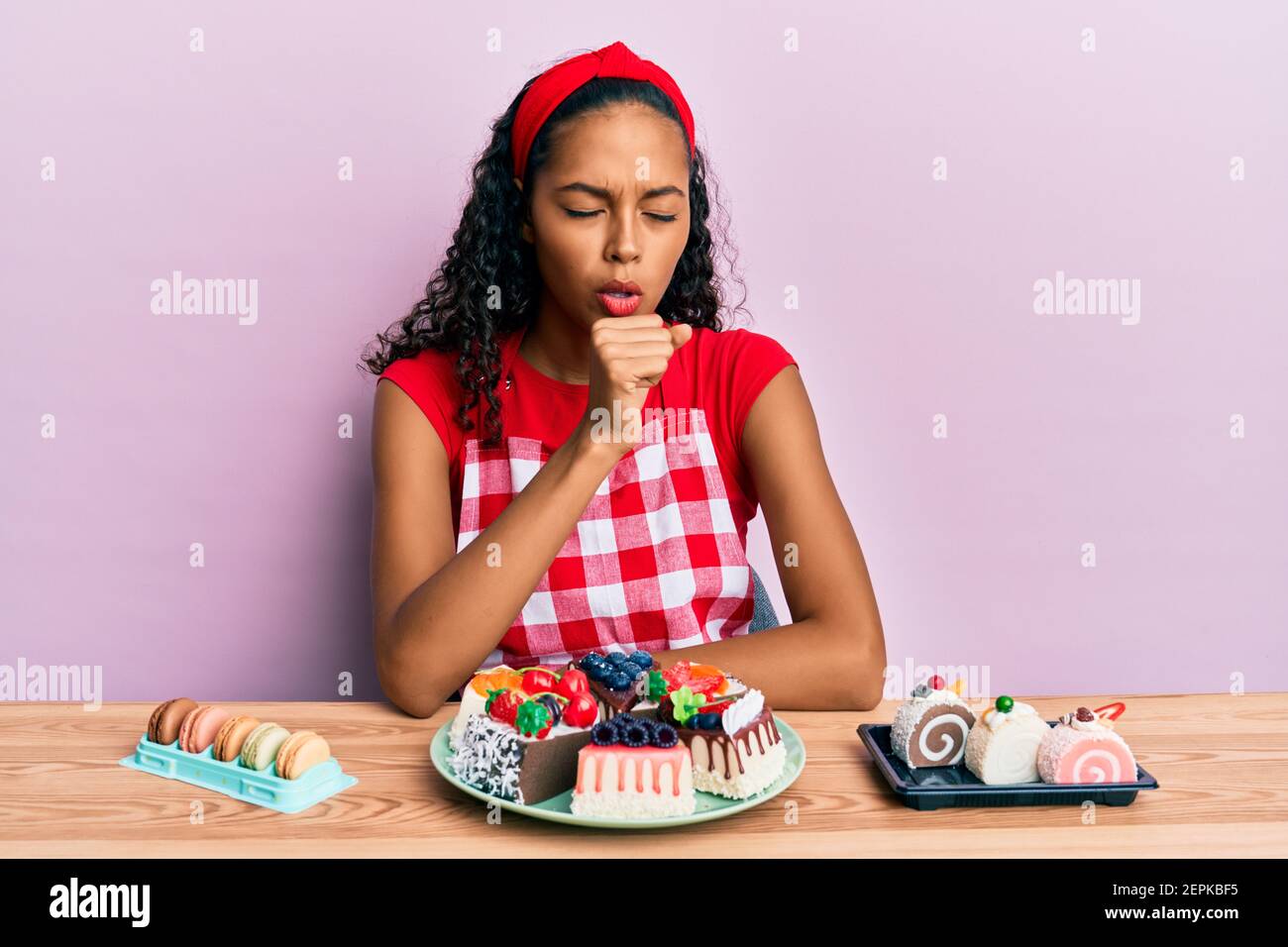 Young african american girl wearing baker uniform sitting on the table