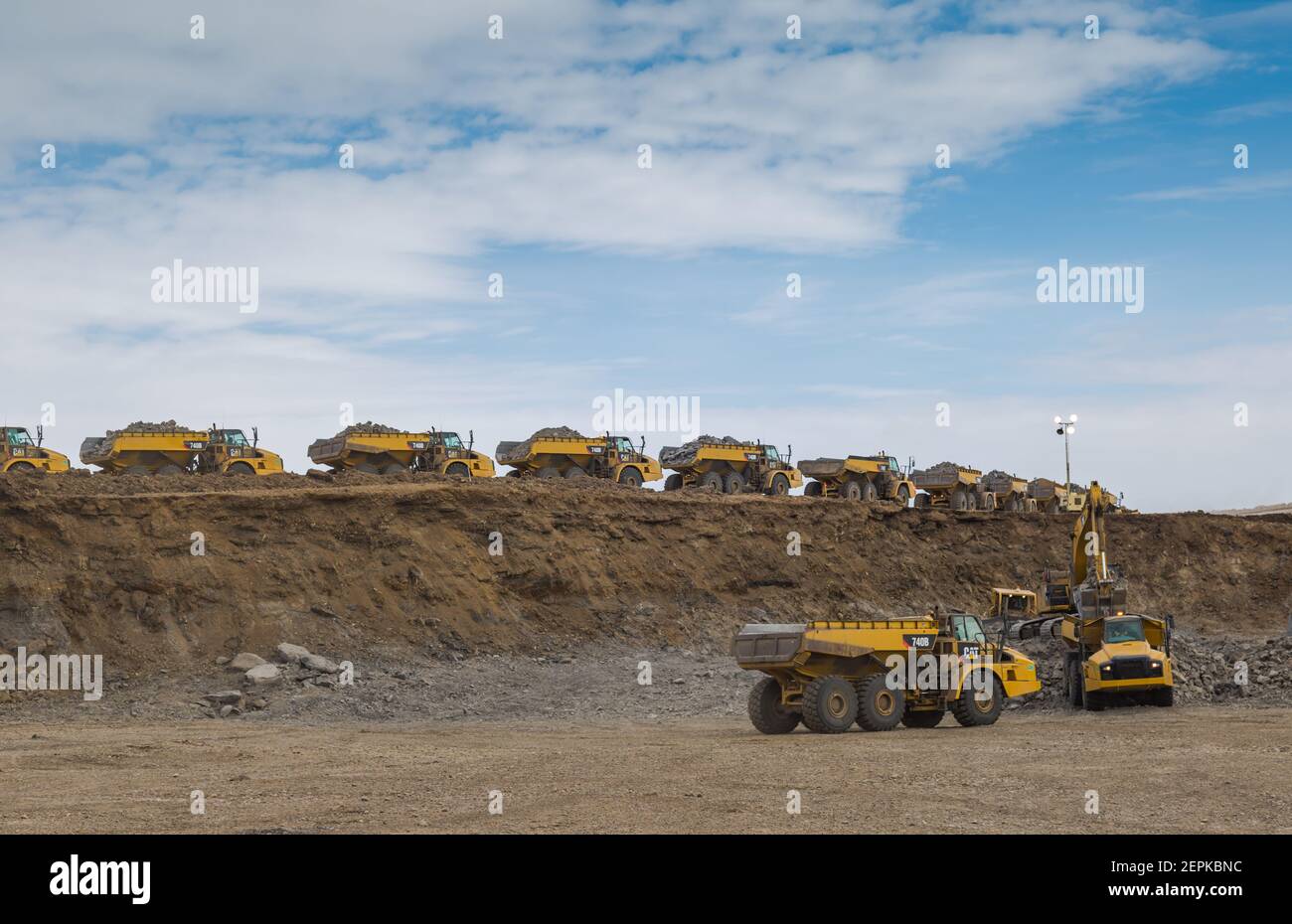 Caterpillar trucks hauling gravel from pit, winter construction of Inuvik-Tuktoyaktuk Highway, Northwest Territories, Canada's Arctic (April 2016) Stock Photo