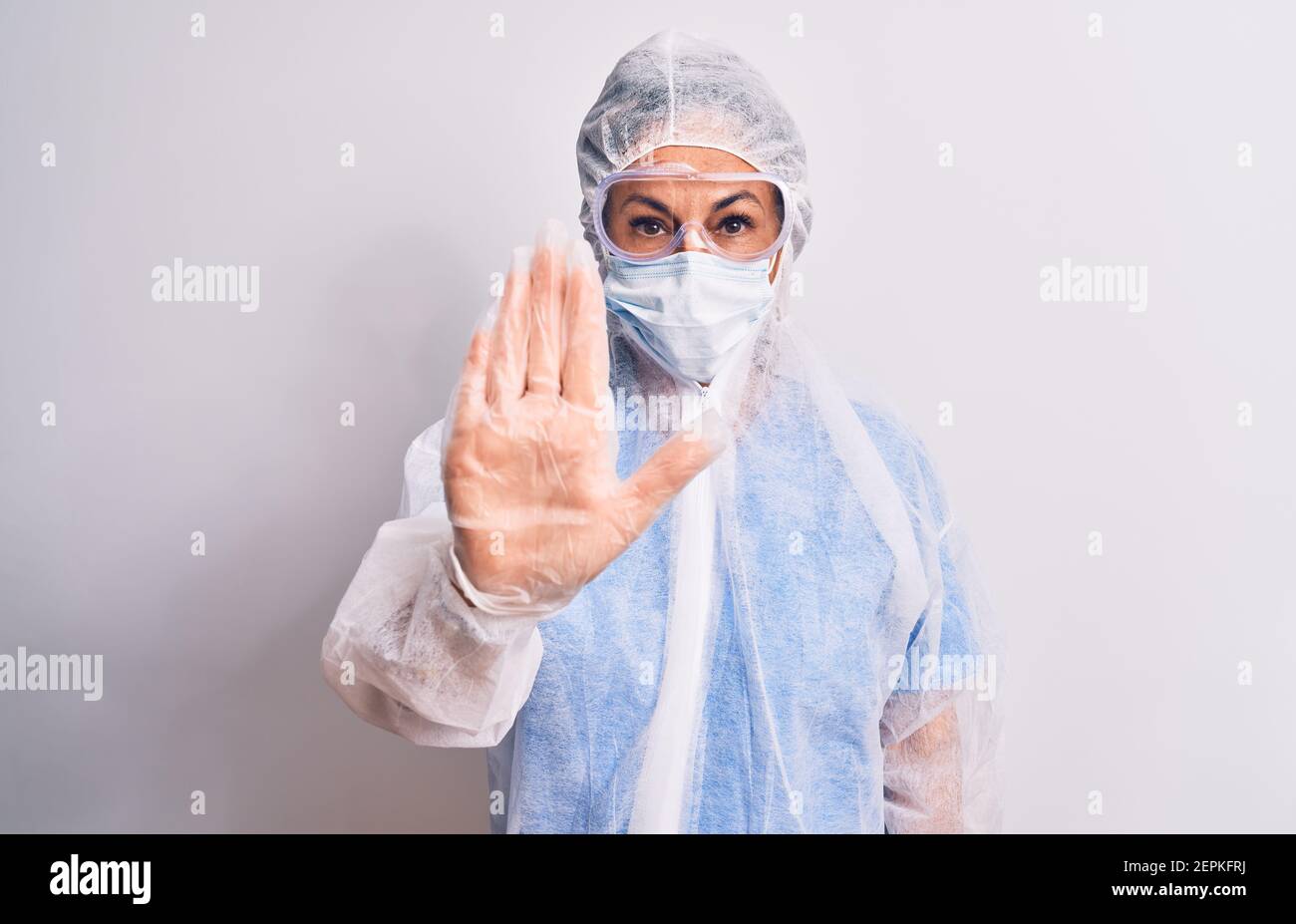 Middle age nurse woman wearing protection coronavirus equipment over ...