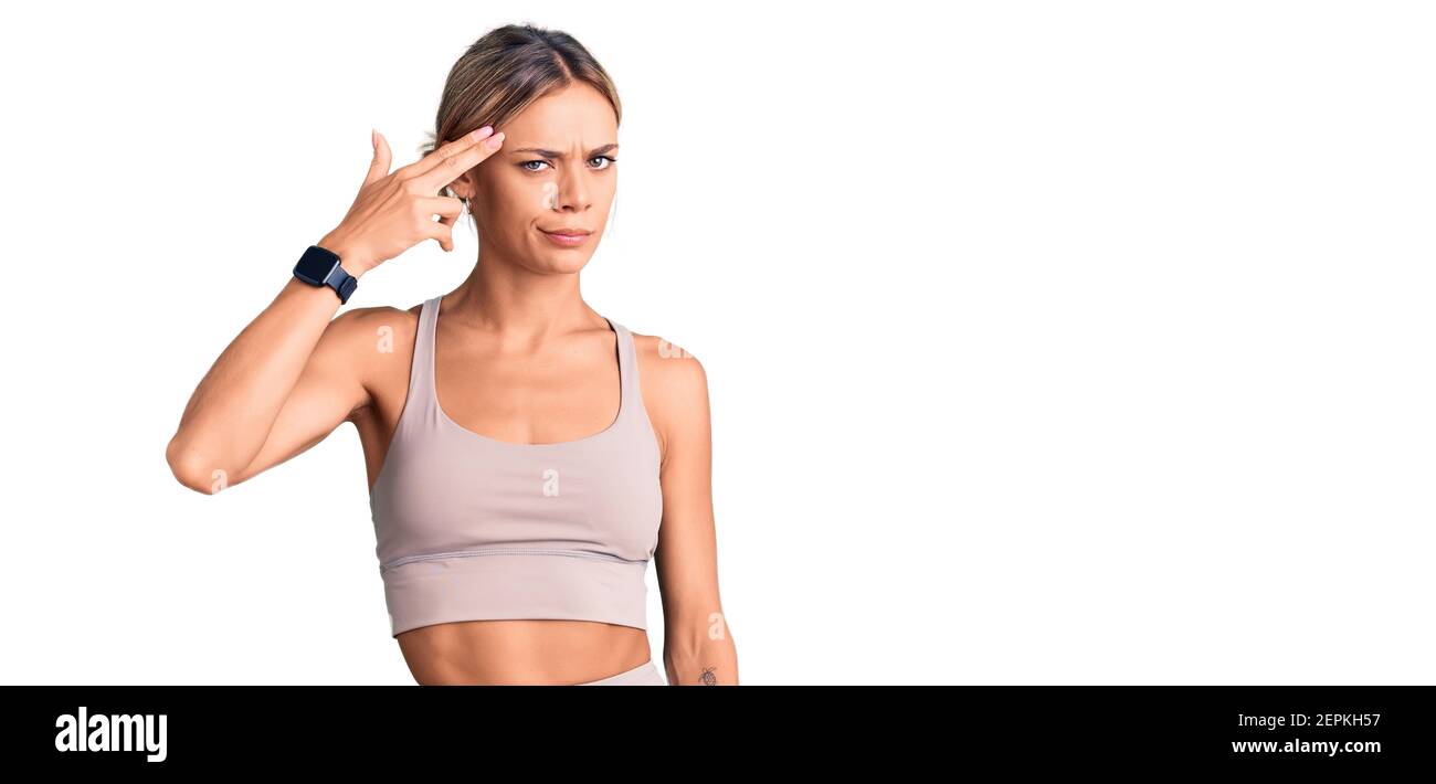 Beautiful caucasian woman wearing sportswear shooting and killing oneself  pointing hand and fingers to head like gun, suicide gesture Stock Photo -  Alamy