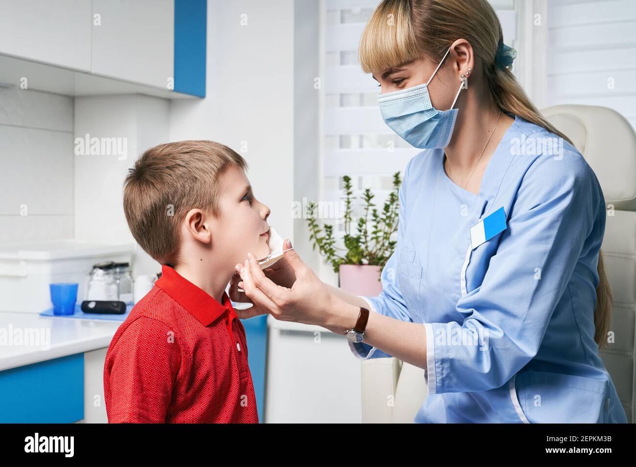 Female ENT doctor taking off or putting on a protective face mask from