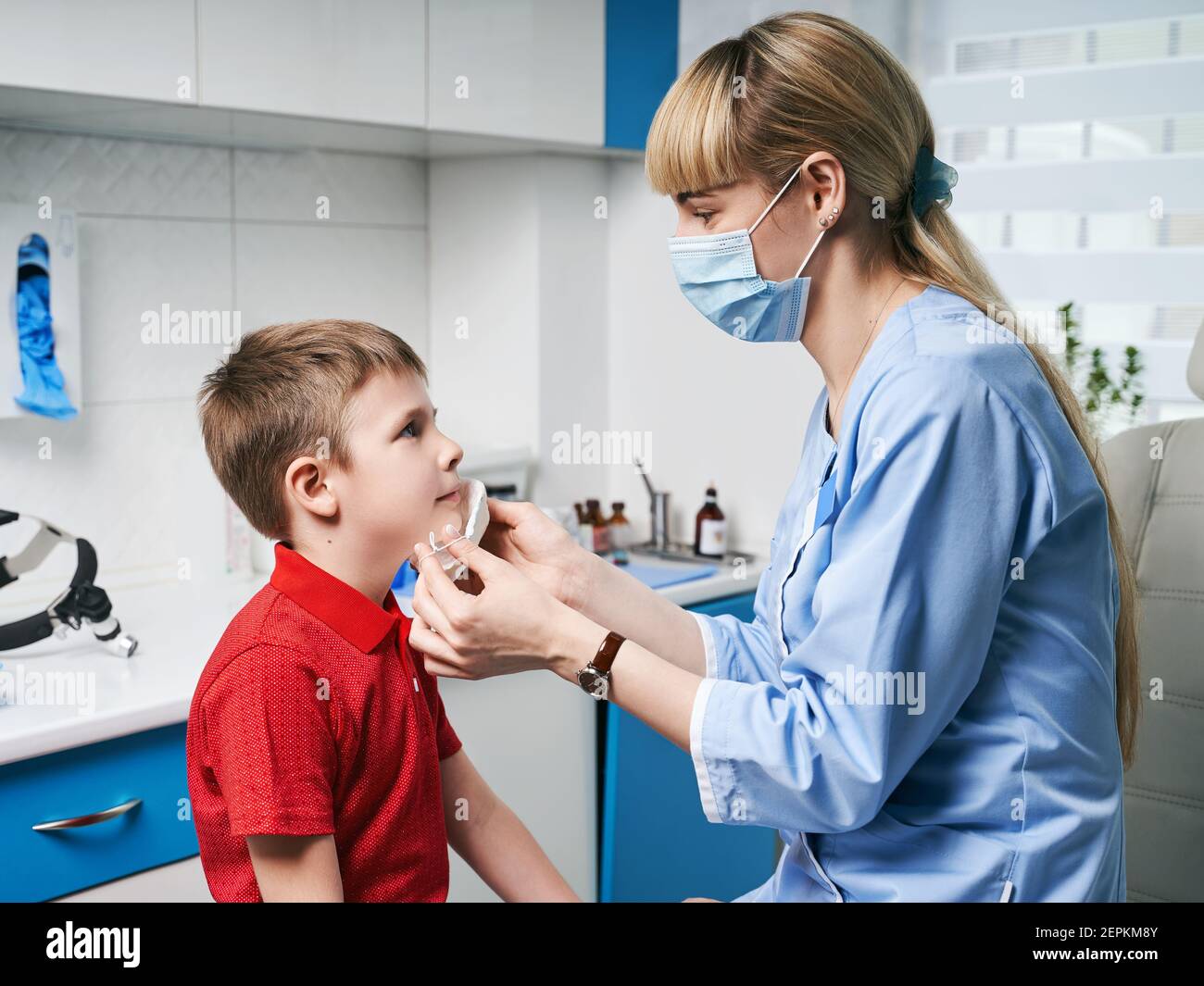 Female ENT doctor taking off or putting on a protective face mask from