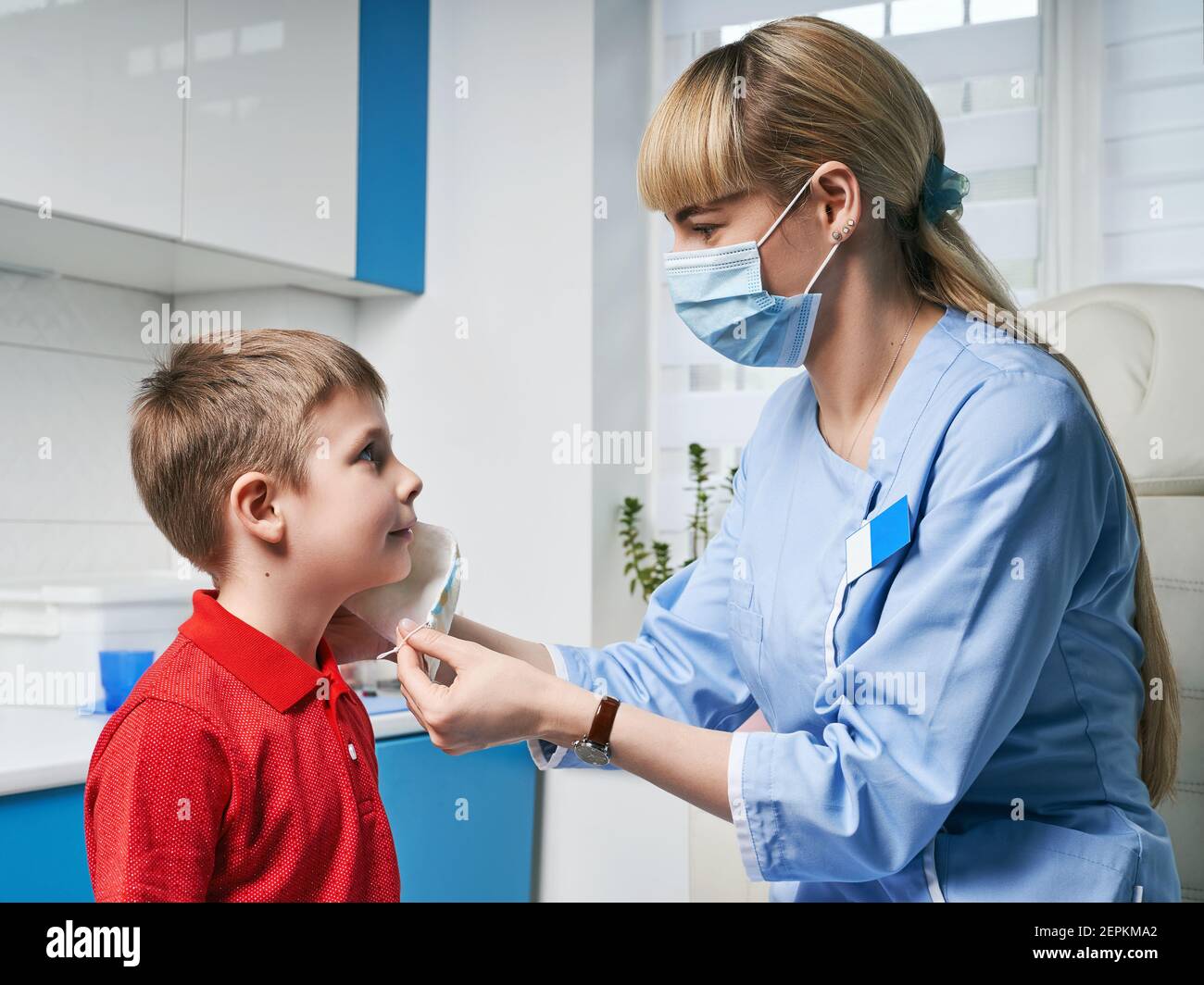 Female ENT doctor taking off or putting on a protective face mask from