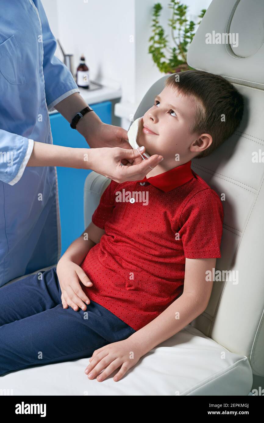 Female ENT doctor taking off or putting on a protective face mask from
