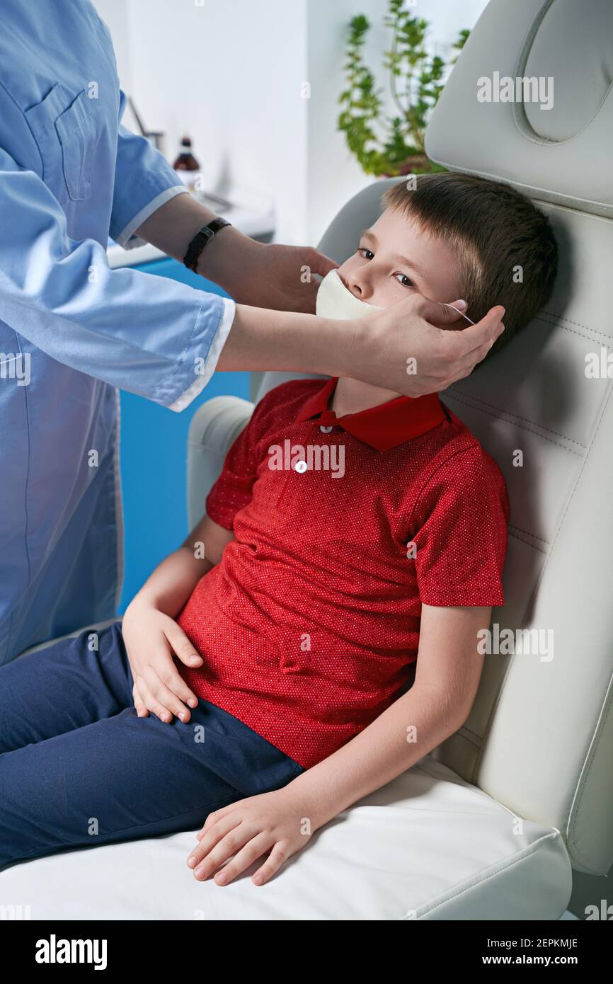 Female ENT doctor taking off or putting on a protective face mask from