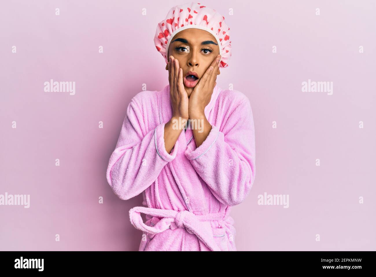 Hispanic man wearing make up wearing shower towel cap and bathrobe ...