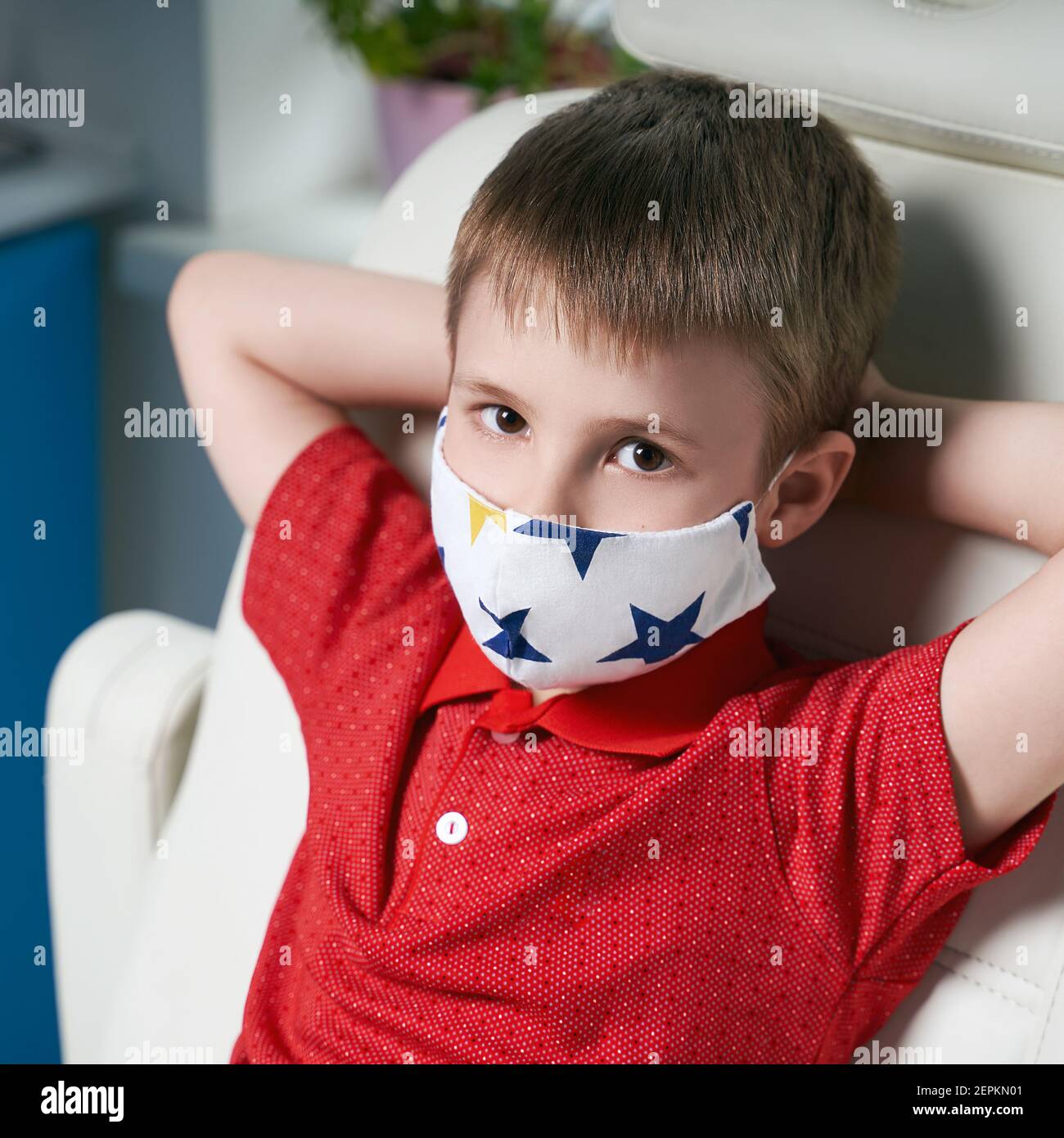 Little boy patient wearing a protective face mask sitting in a medical ...