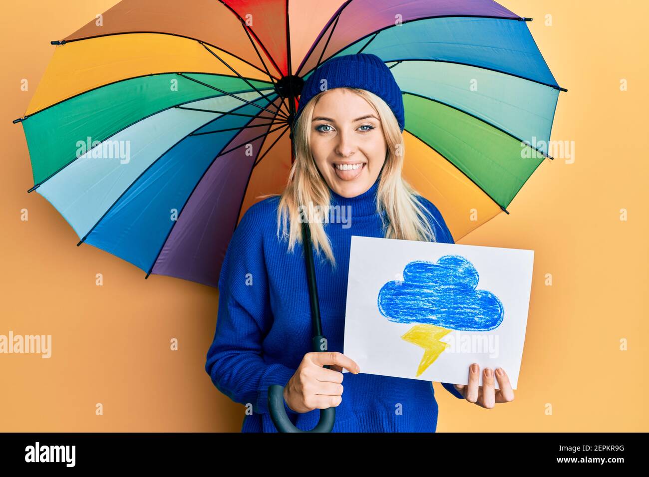 Young caucasian woman holding rain draw and umbrella sticking tongue out  happy with funny expression Stock Photo - Alamy