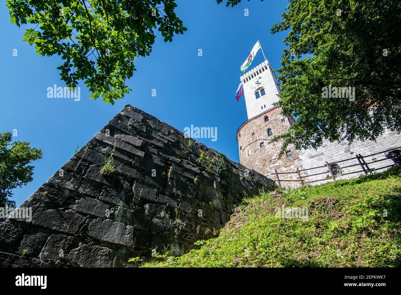 Clock tower of Ljubljana castle with town flag and part of the walls visible, Slovenia Stock Photo