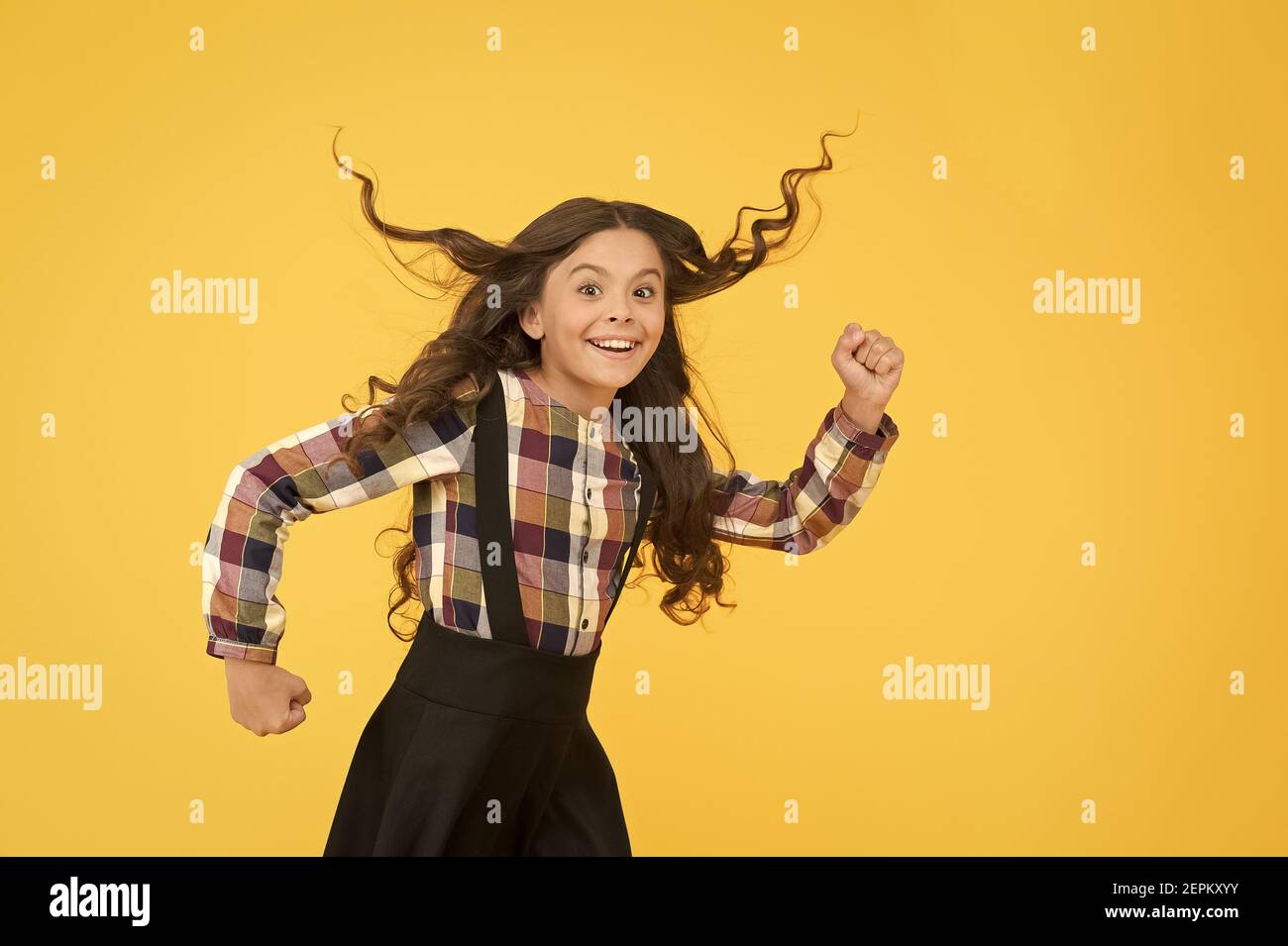 Make haste slowly. Energetic girl hurry to school. Small child wear long hairstyle yellow background. Back to school hairstyle. Hair salon. Fashion hairstyle. School look. Great hairstyle every day Stock Photo - Make haste slowly. Energetic girl hurry to school. Small child wear long hairstyle yellow background. Back to school hairstyle. Hair salon. Fashion hairstyle. School look. Great hairstyle every day Stock Photo -
