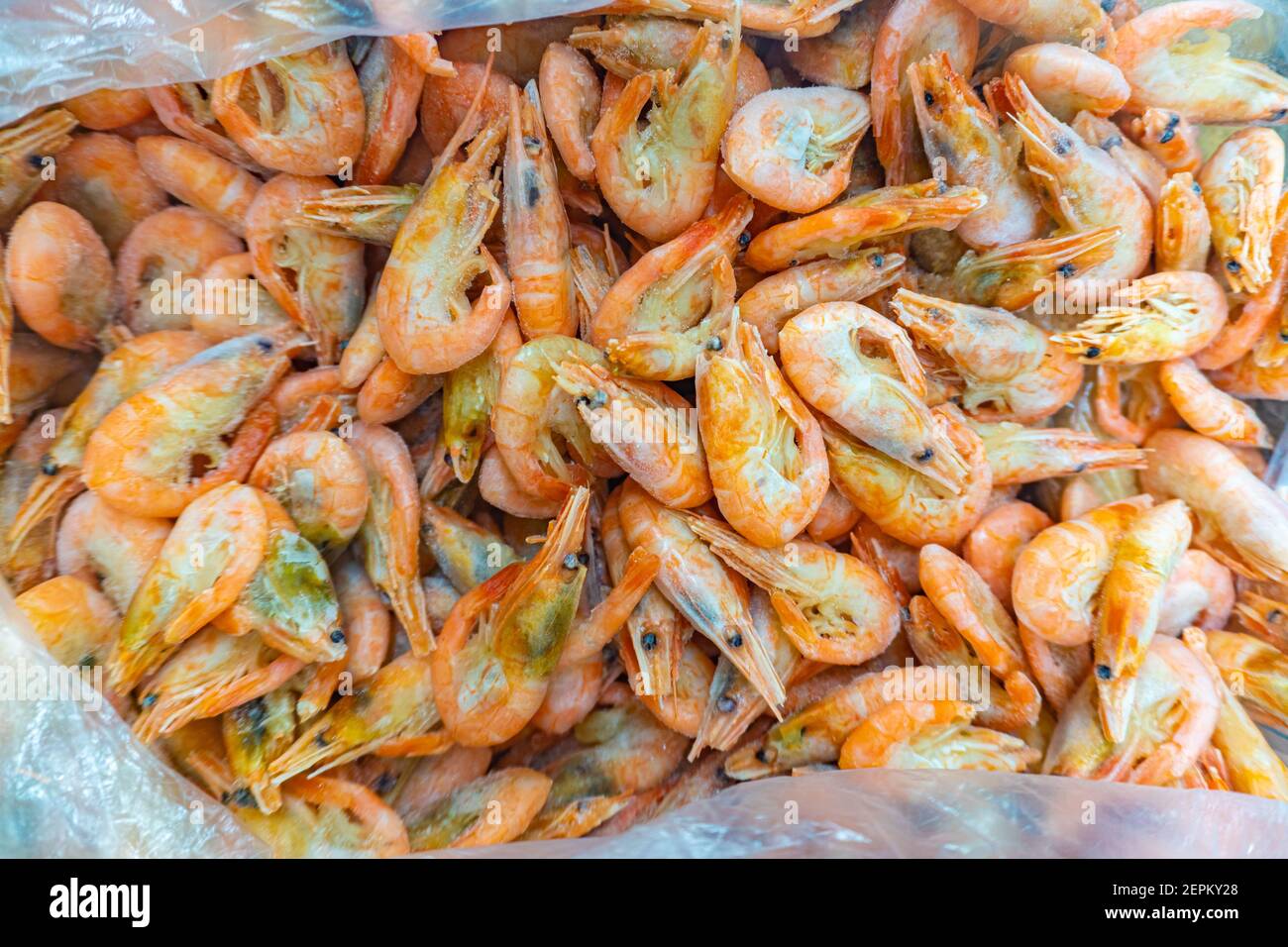 Pink fresh frozen shrimps with ice in a supermarket or fish shop. Fresh frozen prawns, delicacies, sea food concept. Uncooked seafood close up Stock Photo