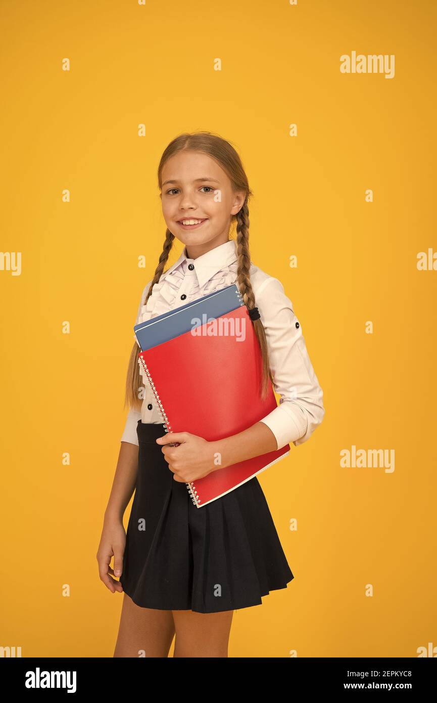 Basic level. Happy schoolgirl hold textbooks yellow background. Little  schoolgirl back to school. Small schoolgirl wear uniform. Cute schoolgirl.  School education. Courses for gifted children Stock Photo - Alamy