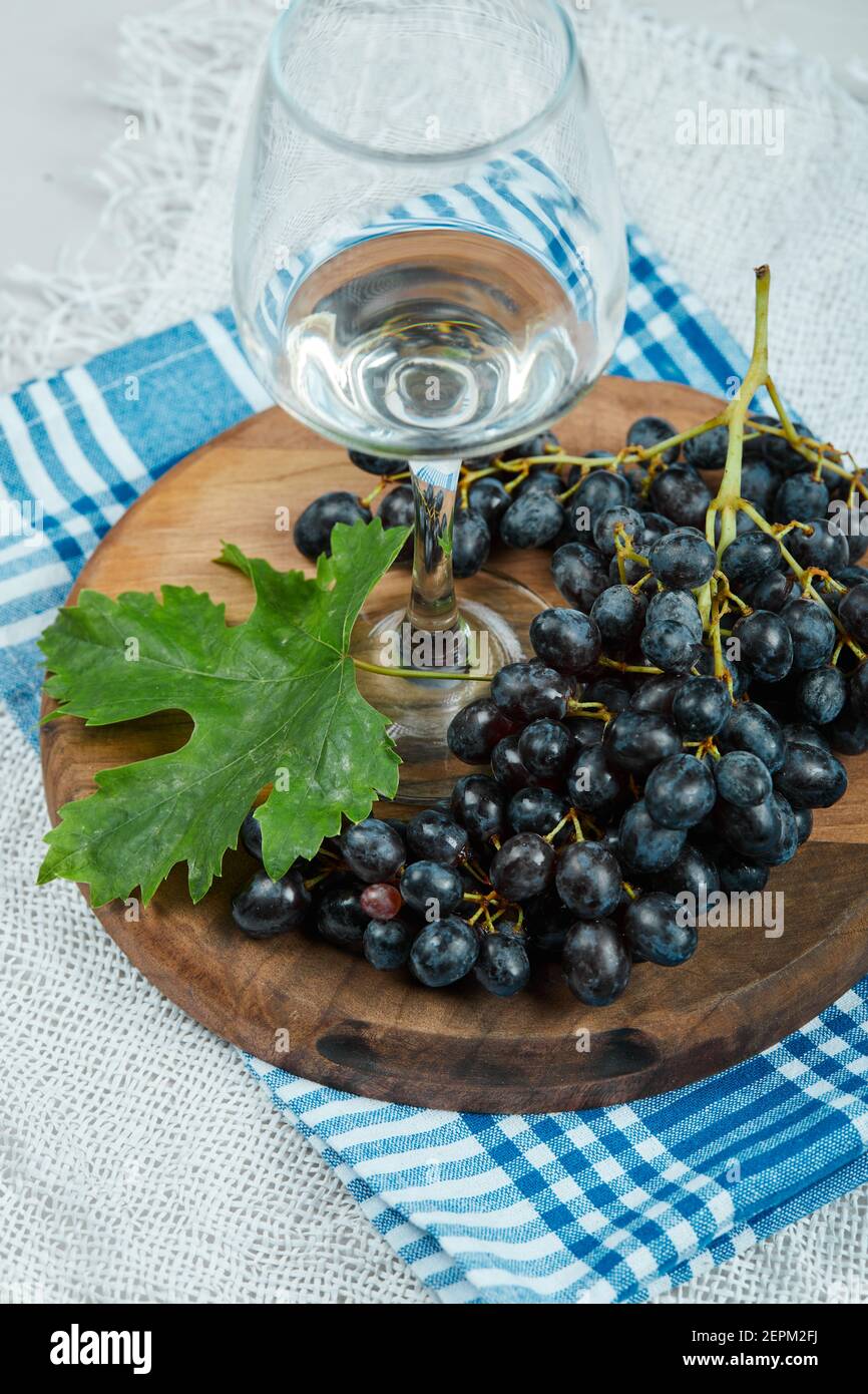 A cluster of black grapes with leaf and a glass of wine on white Stock ...