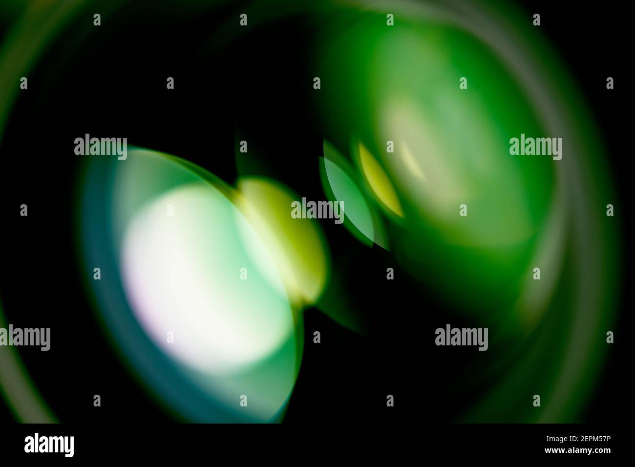 Look into a lens, with green reflections of a round light source Stock Photo