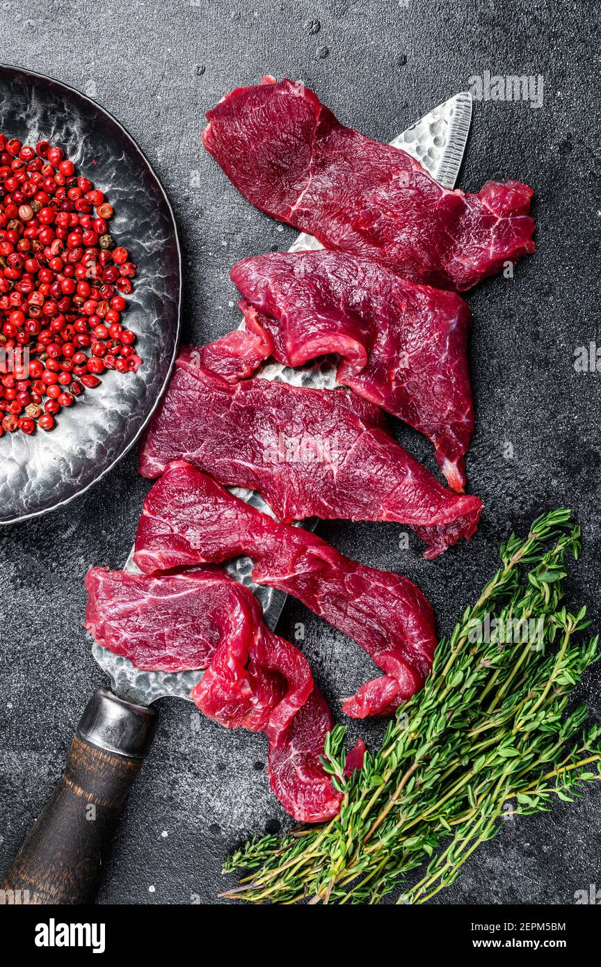Fresh beef marbled meat cut into thin strips for goulash. Black
