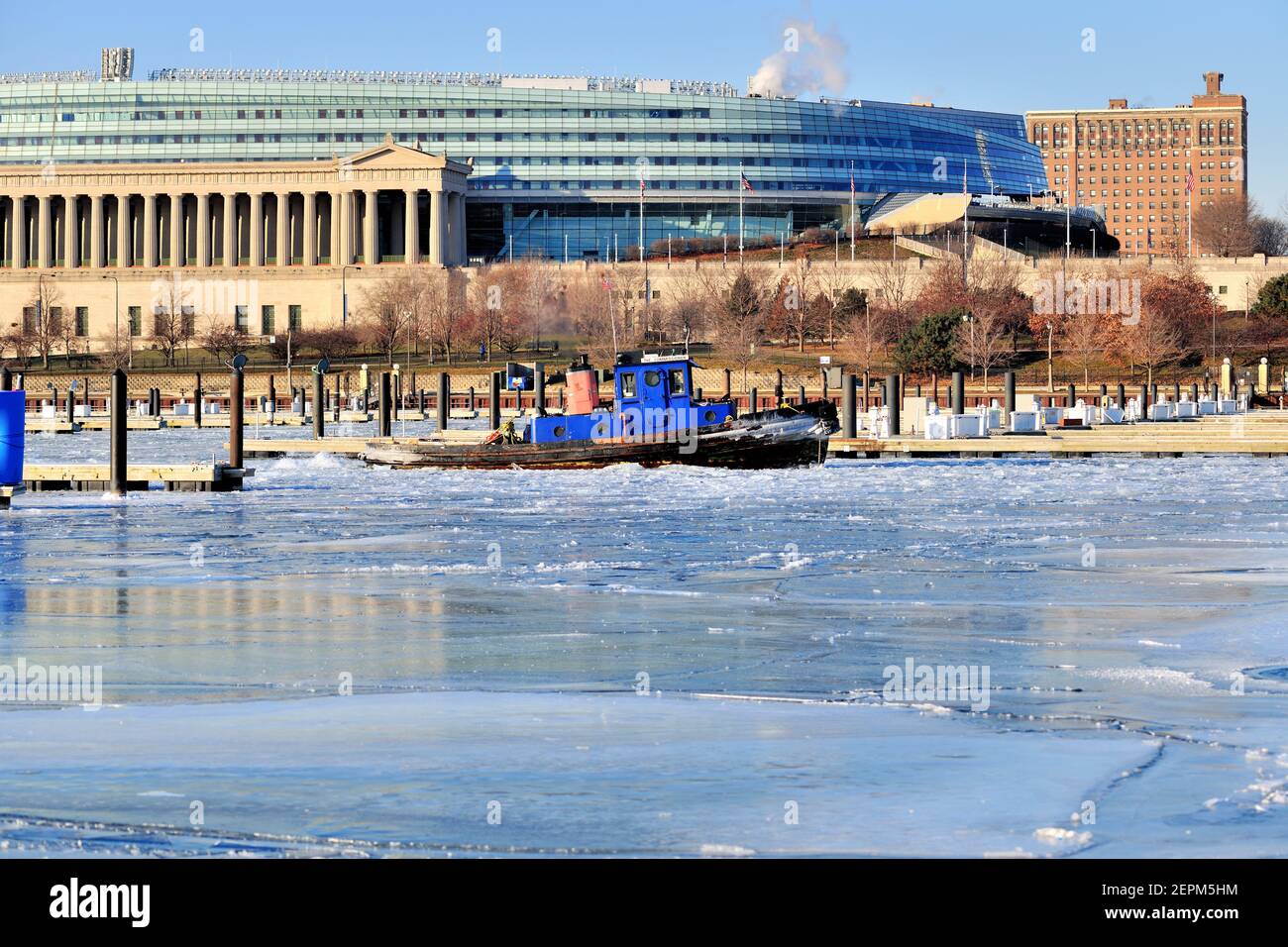 Chicago, Illinois, USA. An ice breaking ship plows through a frozen Burnham Harbor in Chicago attempting to open channels to flowing water. Stock Photo