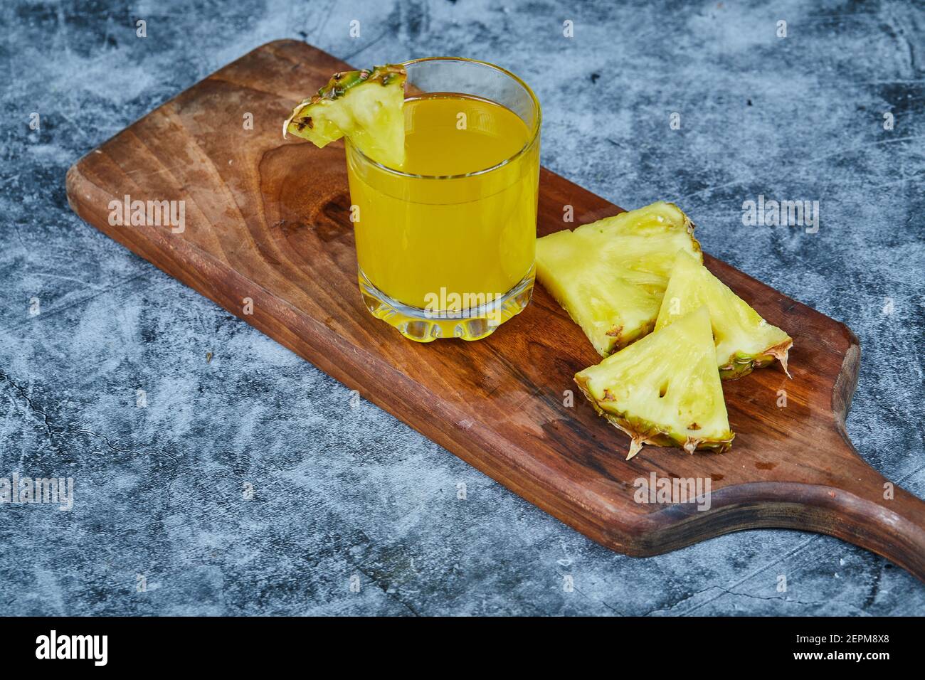 Slices of pineapple and pineapple juice on wooden board Stock Photo