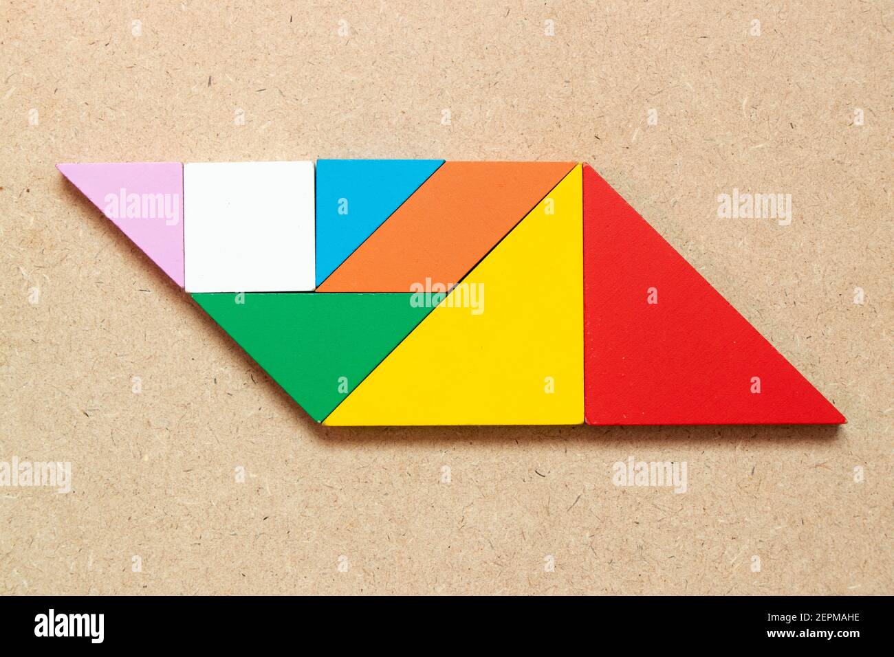 Color tangram puzzle in parallelogram shape on wood background Stock