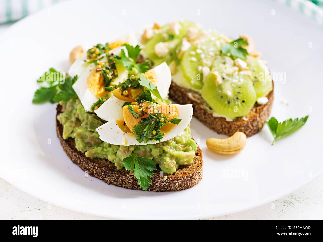 Vegetarian breakfast. Sandwich with avocado puree, boiled eggs and sandwich cream cheese, kiwi