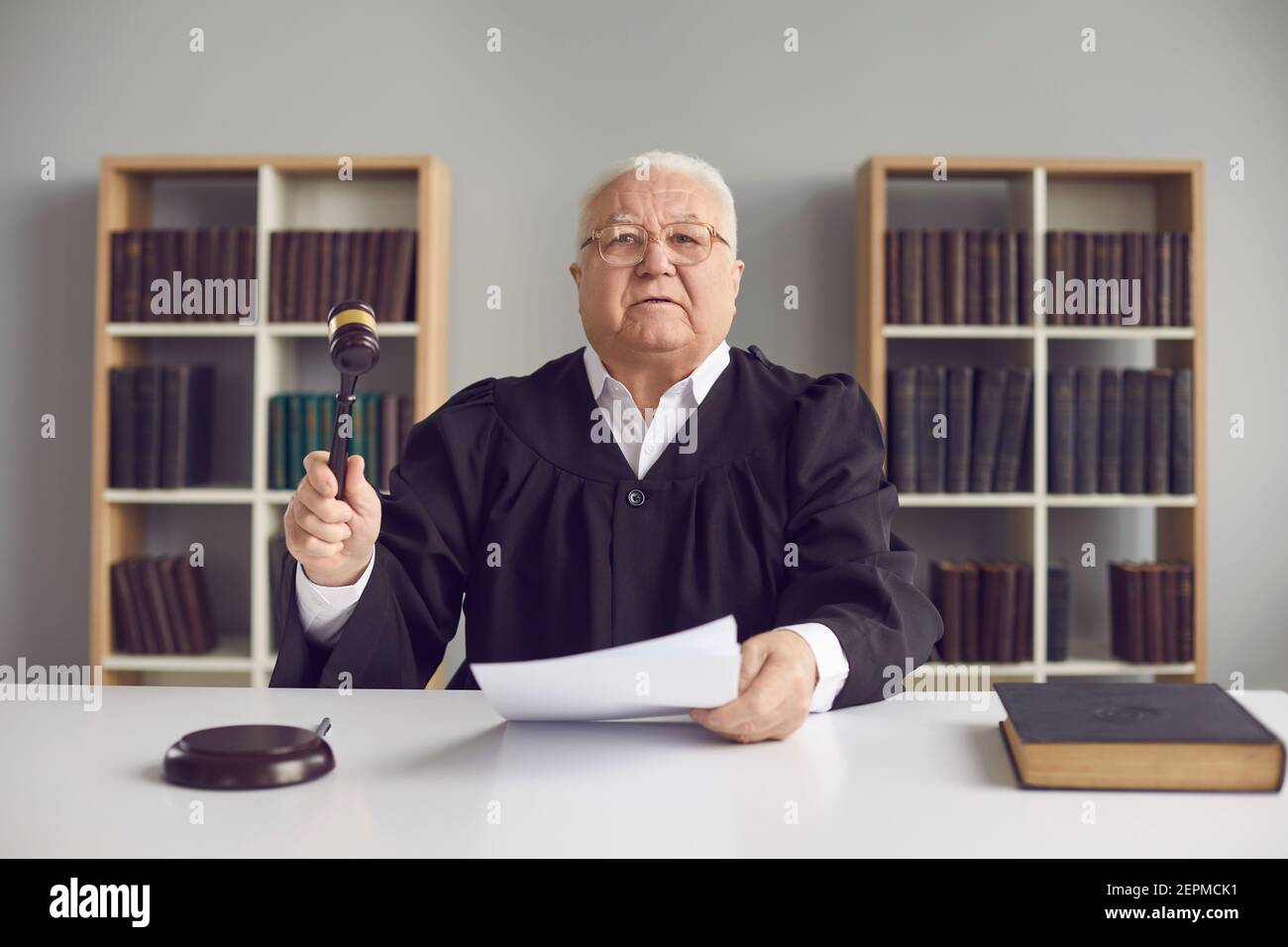Senior judge pronounces sentence, rules case closed and hits sound block with gavel Stock Photo